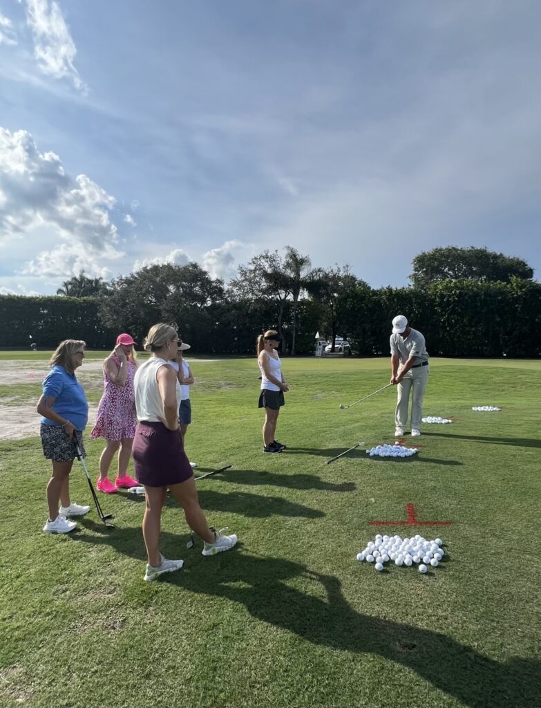 Group of people playing golf on a sunny day.